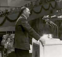 Hitler addresses a crowd in the Sportpalast. Directly behind him sits Joseph Goebbels. 